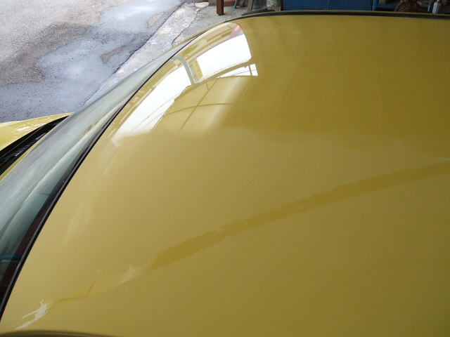 半分がピカピカの黄色い車の屋根